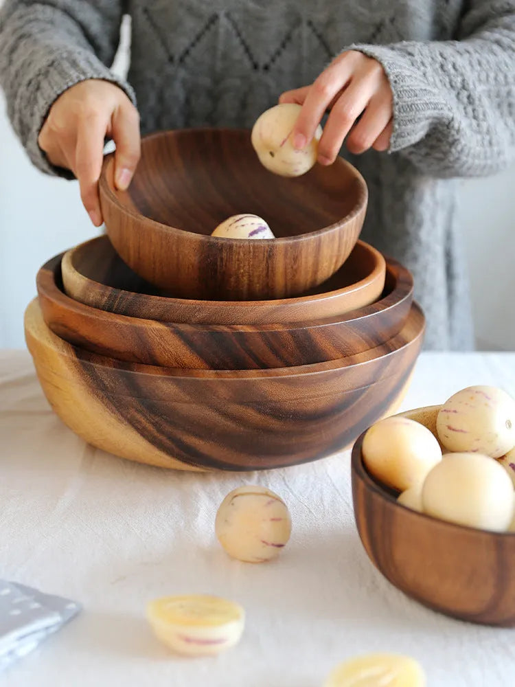 Brown handmade wooden serving bowl with natural wood grain on a table.