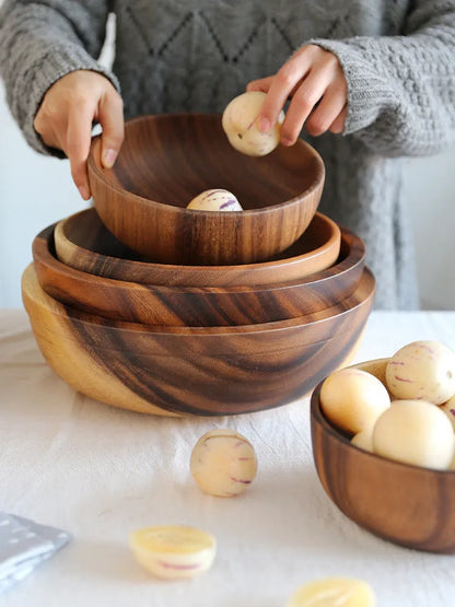 Brown handmade wooden serving bowl with natural wood grain on a table.