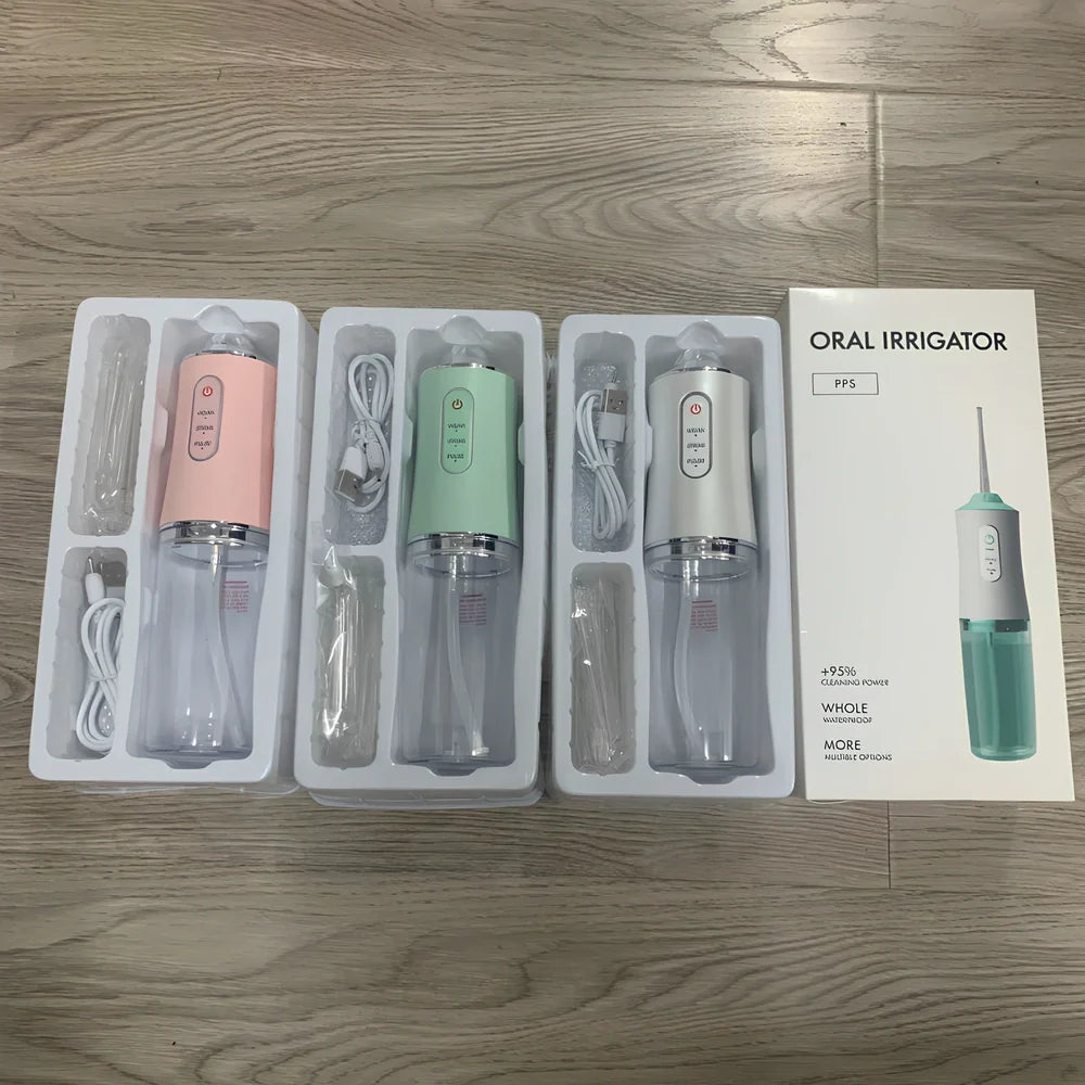 White oral irrigator with 4 nozzles showing water stream and USB charging port