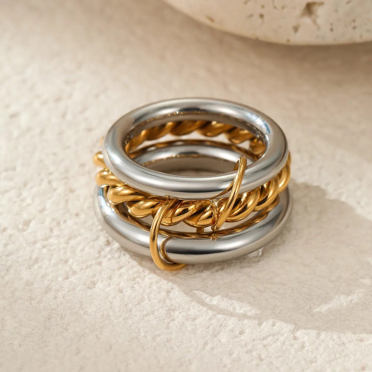 Stacked stainless steel rings with 18K gold plating in three colour variations, exaggerated hand jewellery designs