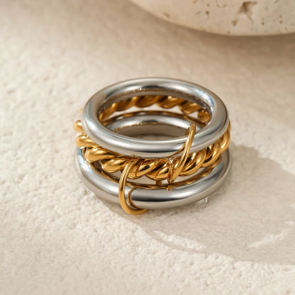 Stacked stainless steel rings with 18K gold plating in three colour variations, exaggerated hand jewellery designs