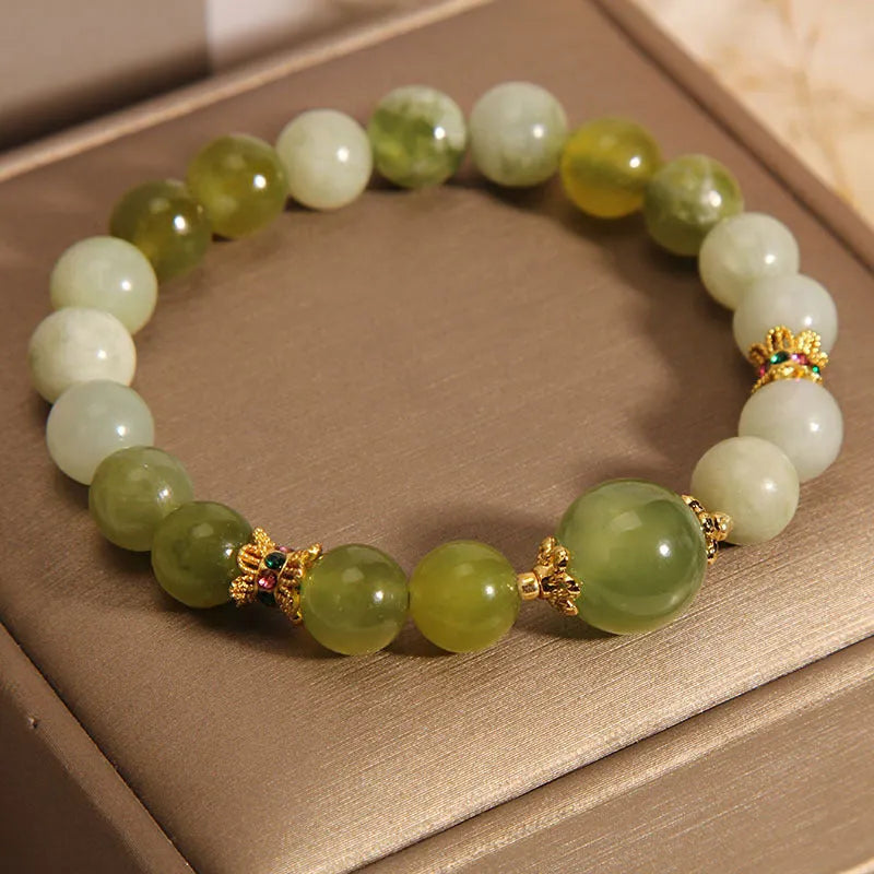 Original design women's bracelet with a green Xiuyan jade stone on wrist.