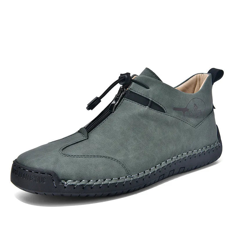 Men's black casual leather shoes with a mid heel, round toe, and visible stitching on a wooden floor.