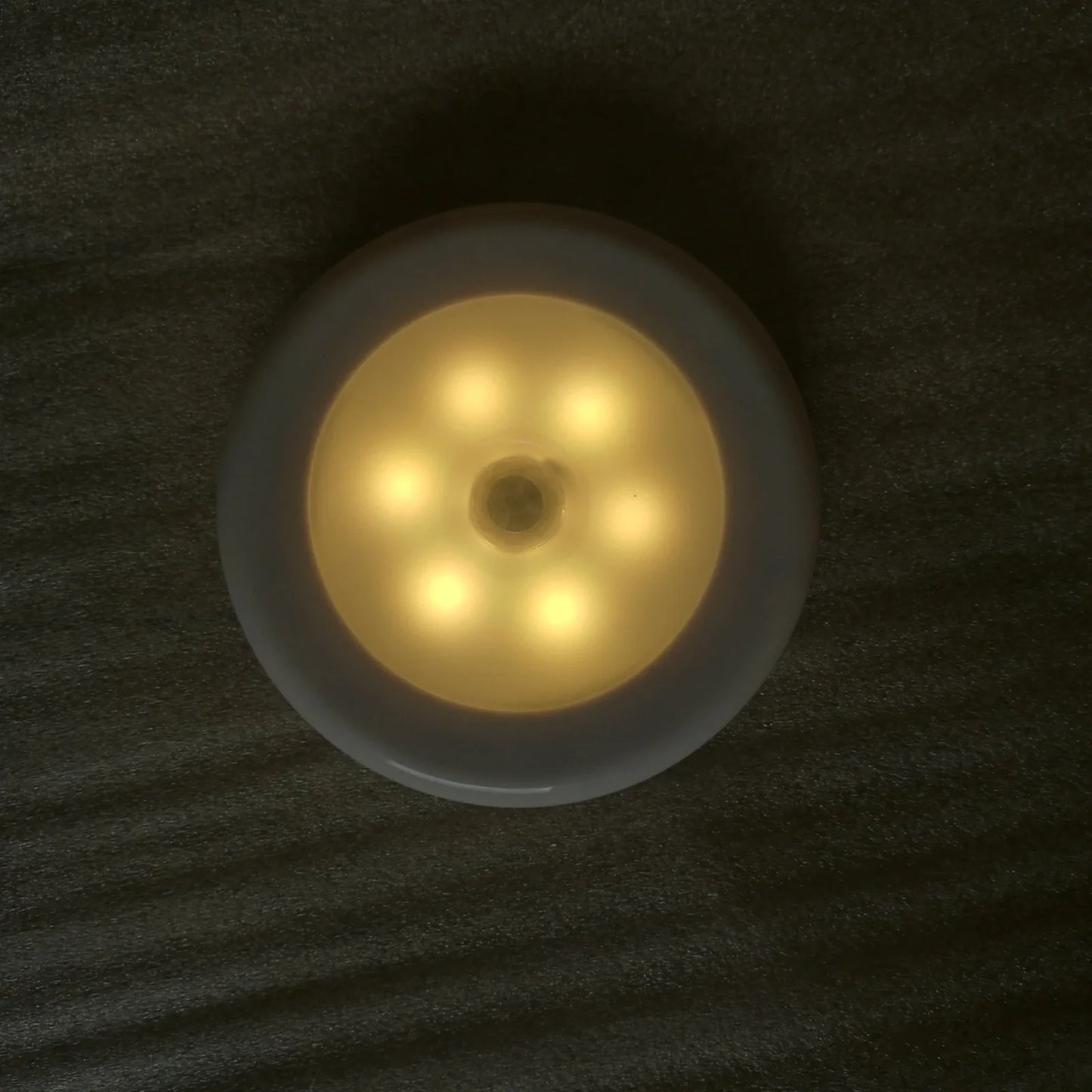 White motion-sensing LED cabinet lamp with magnetic back for wireless installation