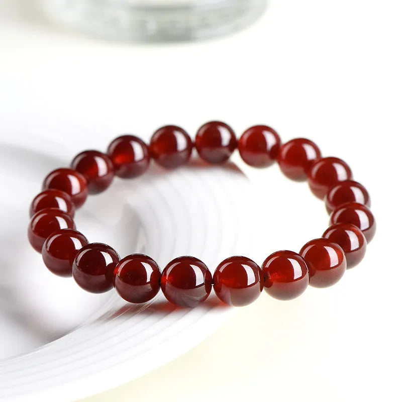 Natural orange red garnet crystal ball bracelet with traditional Ruyi design elements and adjustable bead sizing