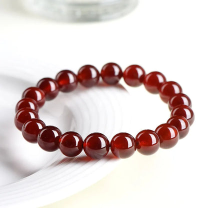Natural orange red garnet crystal ball bracelet with traditional Ruyi design elements and adjustable bead sizing