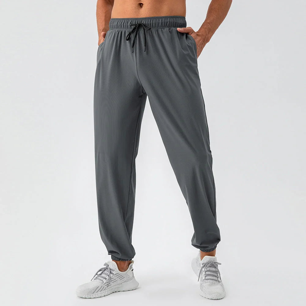 Men's lightweight nylon track pants in various colors, featuring a relaxed, flexible fit for active lifestyles