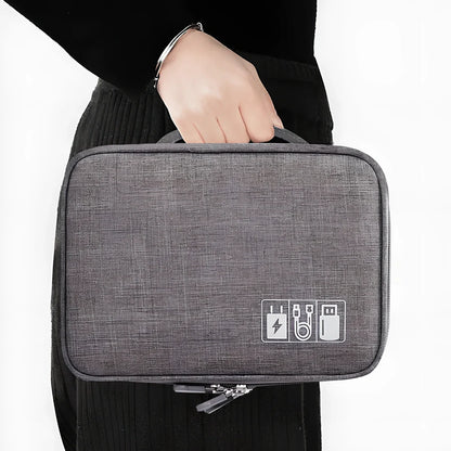 Gray waterproof electronics organiser bag open showing double-layer compartments with elastic loops and mesh pouches