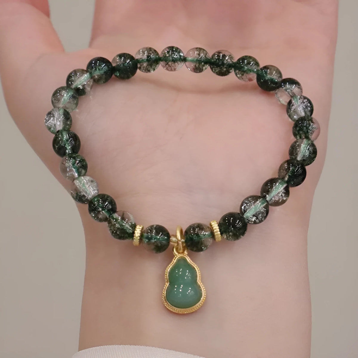 Women's bracelet with citrine, chorite, and a green phantom quartz heart charm.