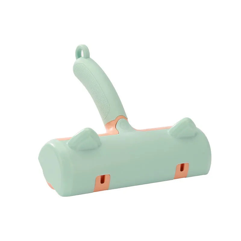 Mint green plastic cat hair removal brush with an ear-style handle on a fabric sofa.