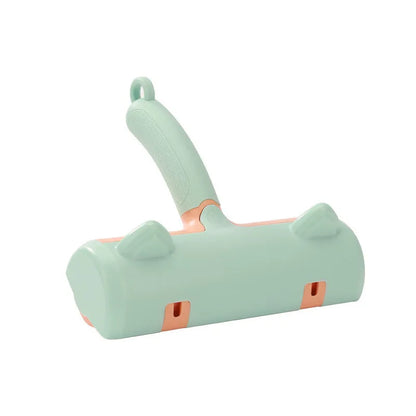 Mint green plastic cat hair removal brush with an ear-style handle on a fabric sofa.