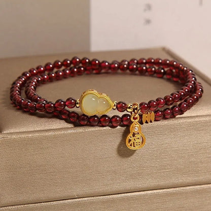 Handmade antique Chinese style bracelet with red imitation garnet and pomegranate design in a gift box.