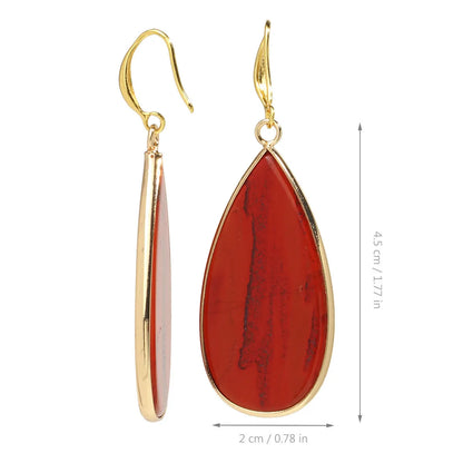 Close-up of long, polished tigereye stone drop earrings with a fishhook clasp on a neutral background.