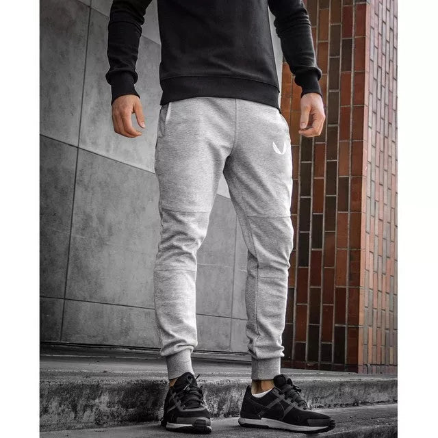 Running training pants in black, light gray, or dark gray with 95% cotton fabric and cord closure