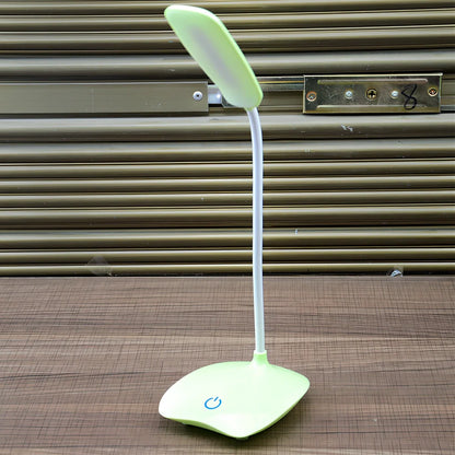 White foldable LED desk lamp with touch button and USB charging port on a desk