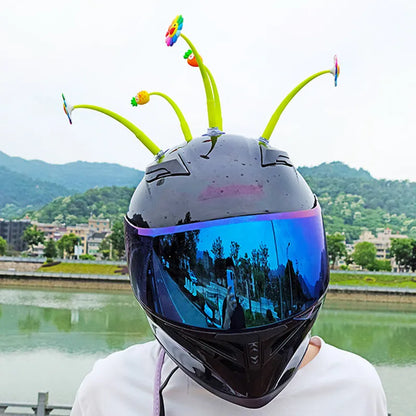 Yellow silicone sunflower decoration with suction cup attached to bicycle helmet, showing swinging motion