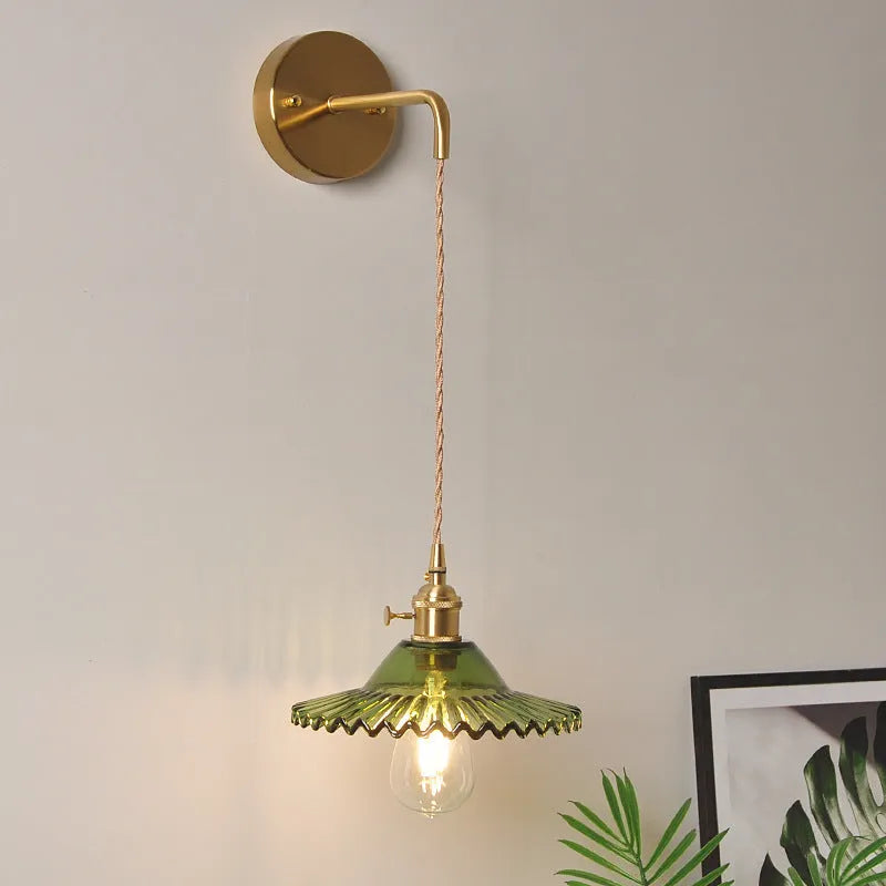 Retro brass lotus wall lamp with copper body and glass shade in various colours, mounted on a wall