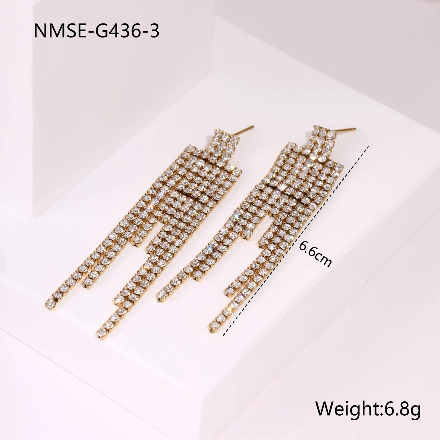 Gold-coloured women's earrings with a love heart shape, star details and dangling diamond-style tassels on a white background.