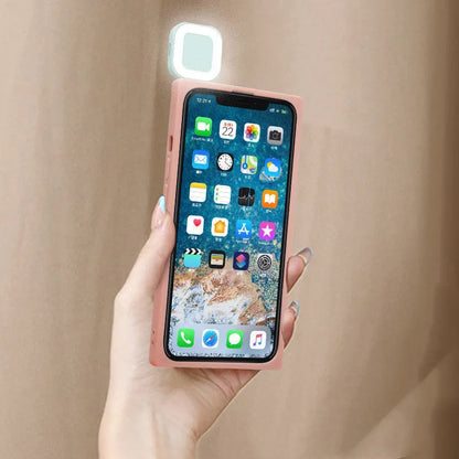 Pink mobile phone case with built-in ring flash light for Apple iPhone 13 models on a white background.