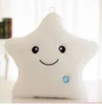 Colourful glowing five-pointed star plush pillow on a dark background.