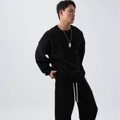 Man wearing a two-piece army green polar fleece suit with crew neck top and padded trousers.