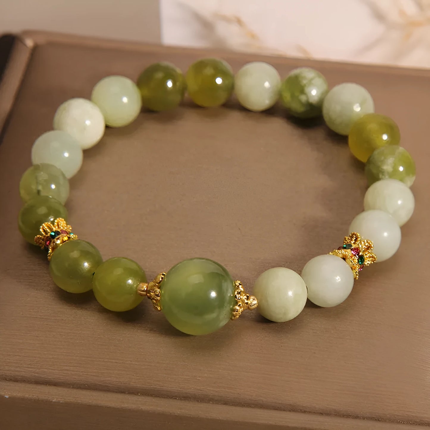 Original design women's bracelet with a green Xiuyan jade stone on wrist.