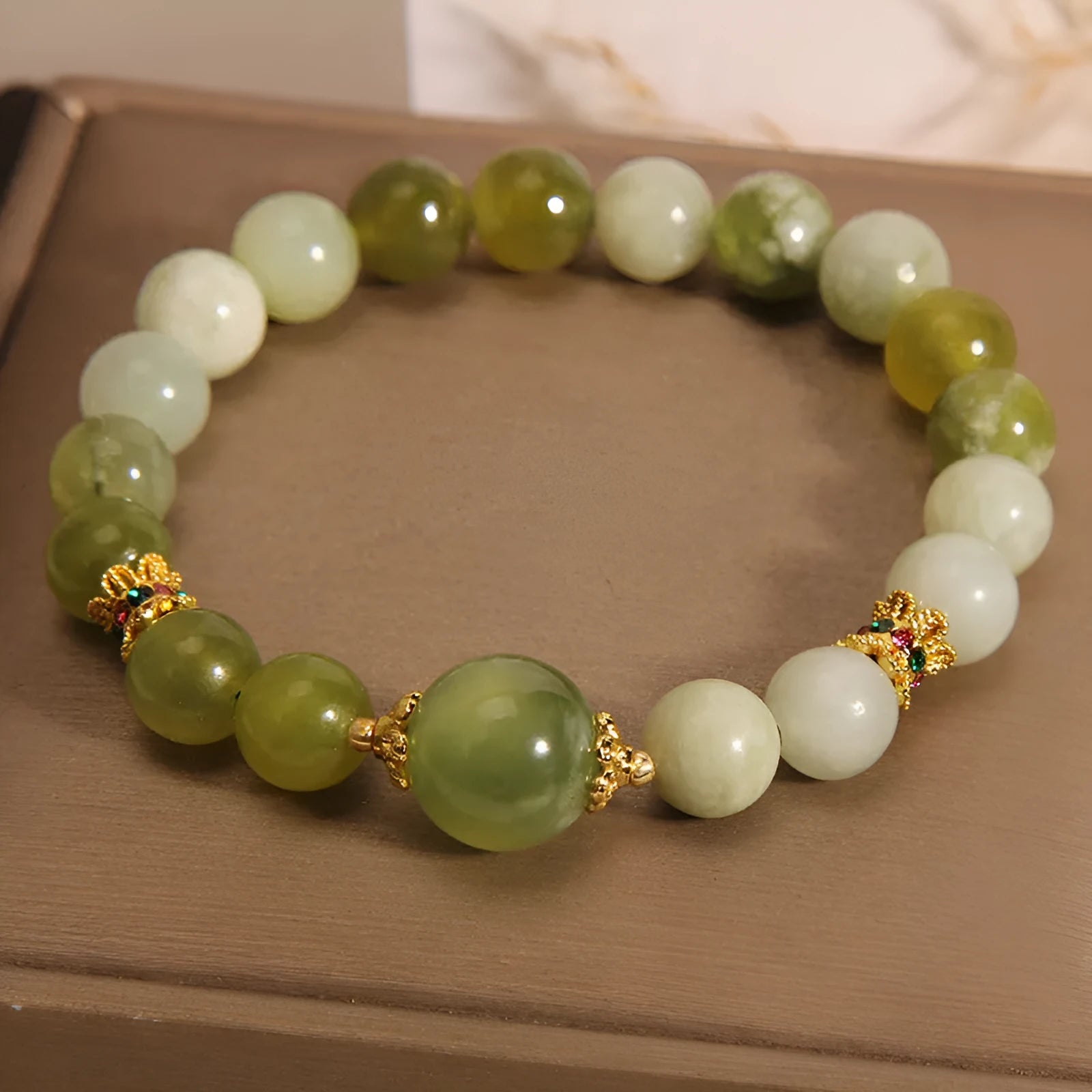Original design women's bracelet with a green Xiuyan jade stone on wrist.