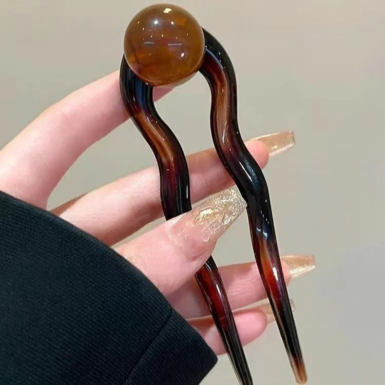 Acrylic U-shaped hair barrette with retro ball design in caramel colour