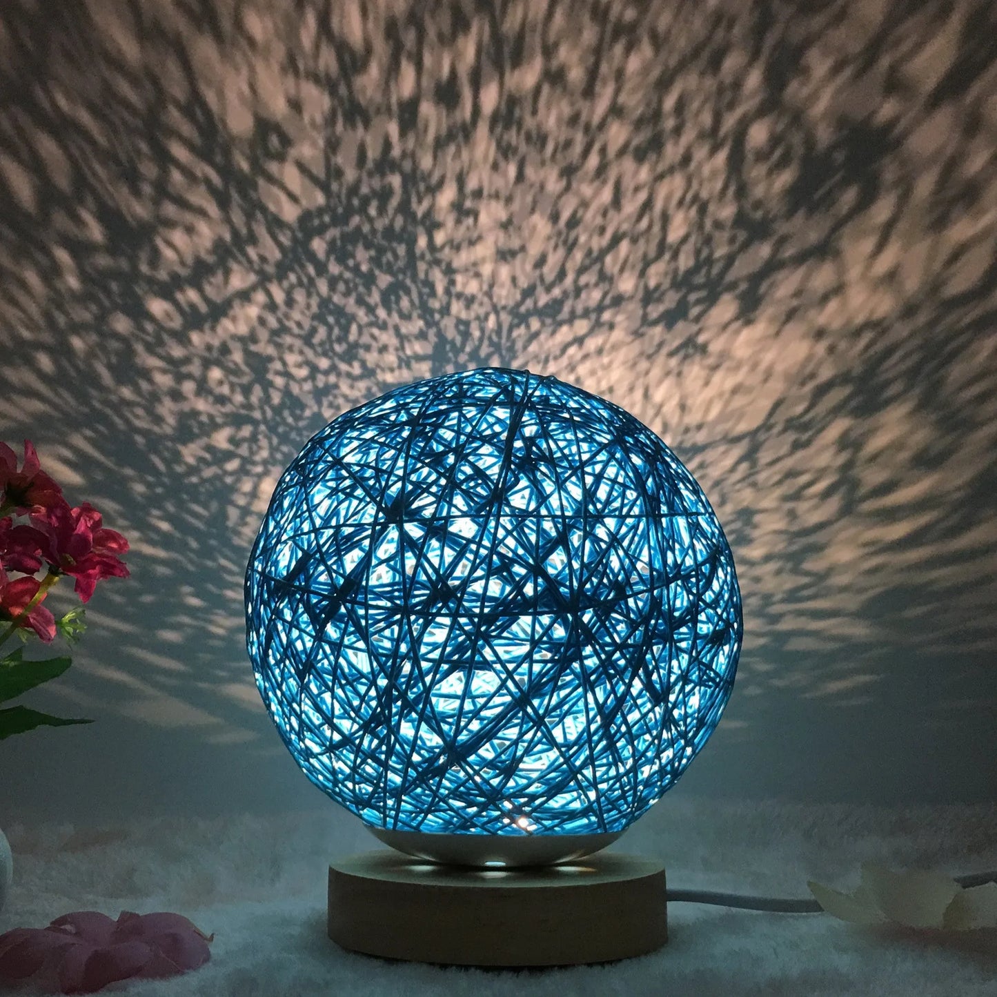 Spherical hand-knitted rattan table lamp with remote control on a wooden desk