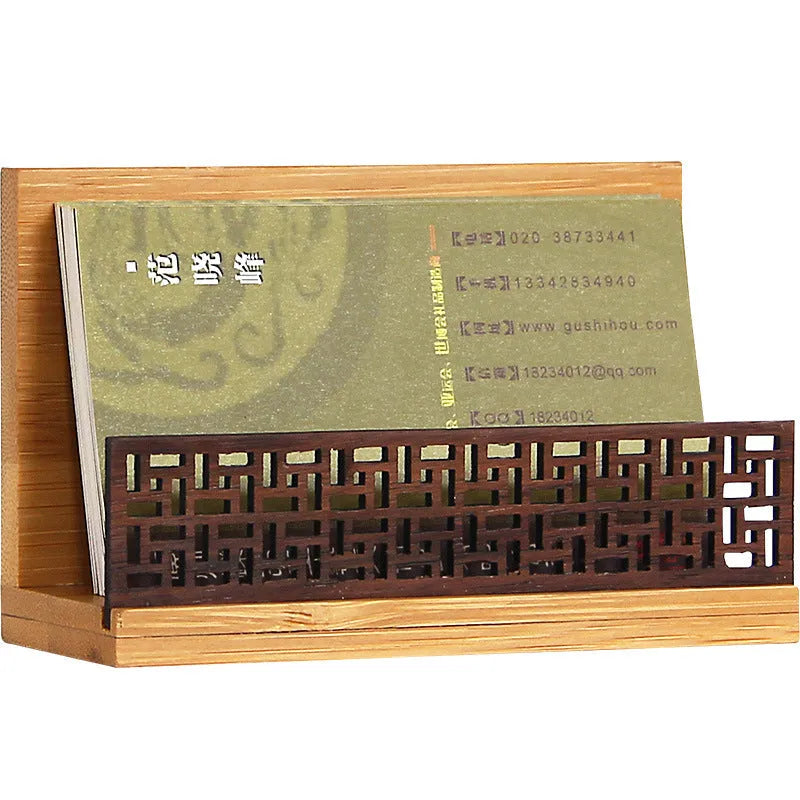 Geometric bamboo and black walnut wood business card holder on a desk.