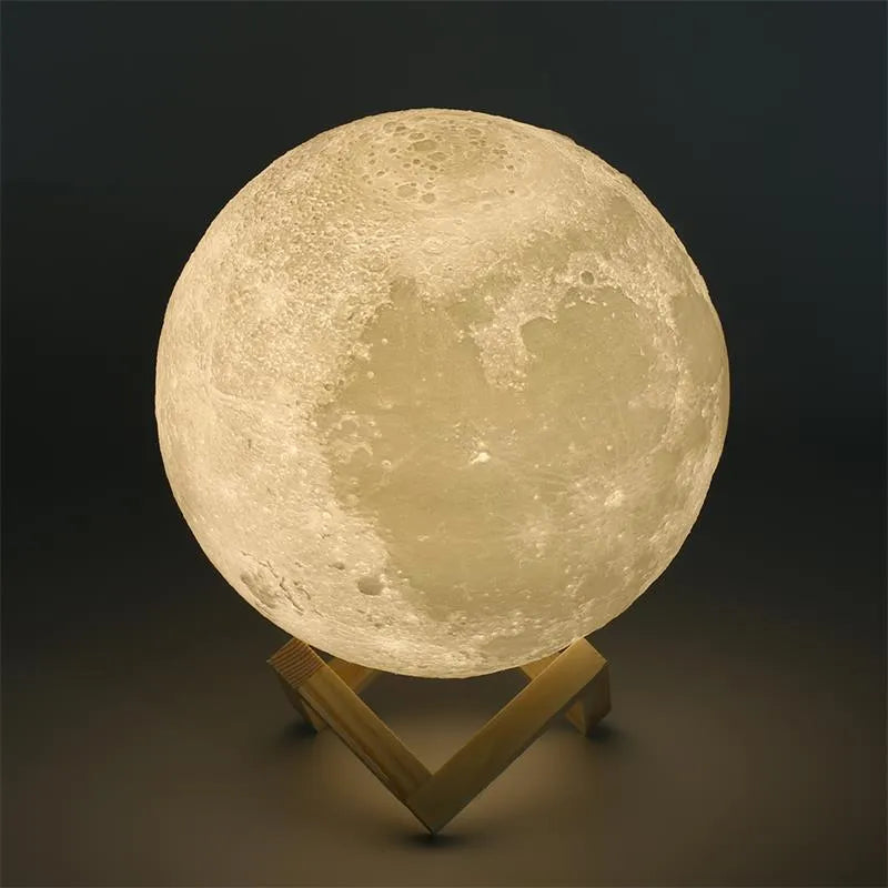 3D printed white moon lamp glowing on a wooden stand, showing detailed crater texture on its surface.
