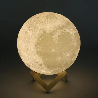 3D printed white moon lamp glowing on a wooden stand, showing detailed crater texture on its surface.