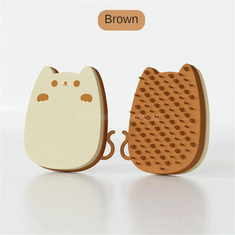 Blue silicone and sponge pet grooming brush with dual comb teeth on a wooden surface.