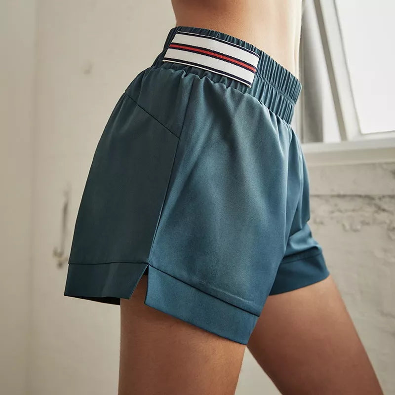 Female fitness yoga shorts in green, made with 95% polyester fiber blend for durability and comfort