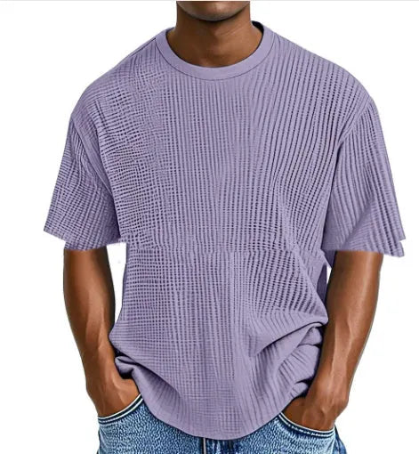 Man wearing a light blue waffle-textured cotton blend short sleeve t-shirt, casual pullover style.