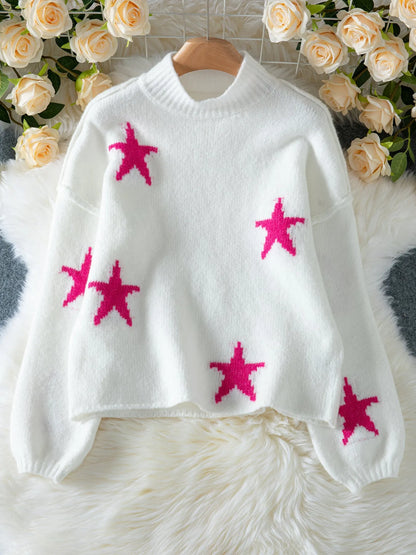 White women's turtleneck pullover with a black star pattern, loose fit, and long sleeves.
