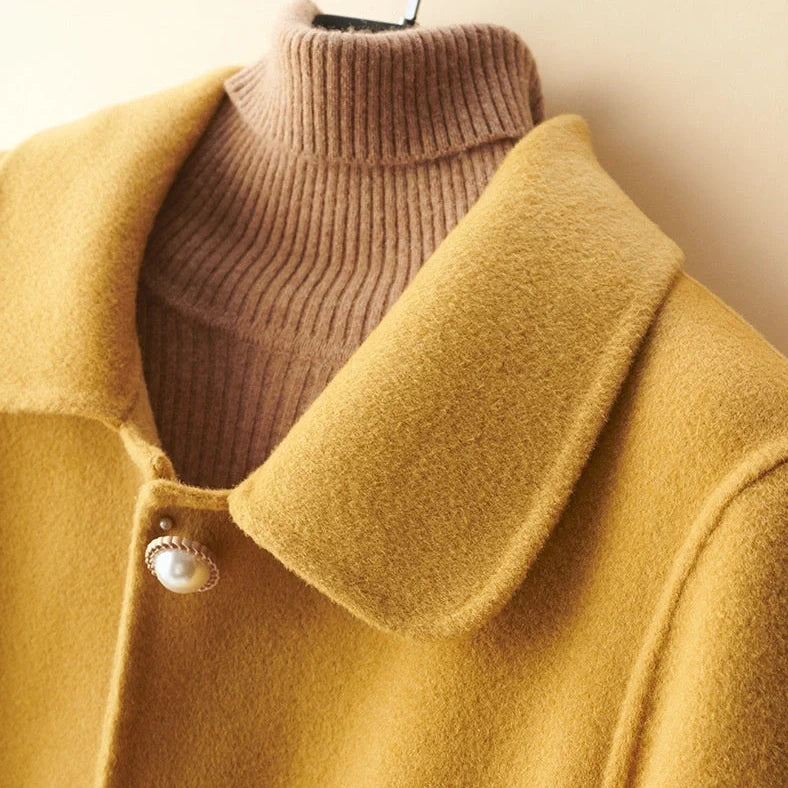 Women's black wool mid-length coat with doll collar and pearl buckle, showing double-faced fabric and 65cm length.