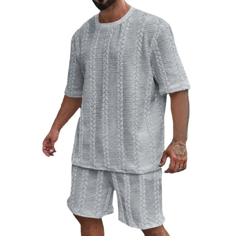 Knitted short-sleeve pullover and matching shorts set in light grey, laid flat.