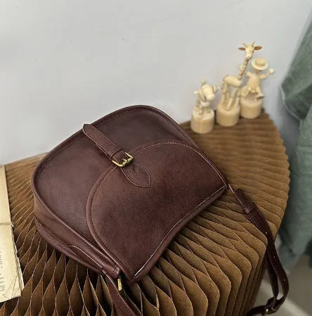Genuine leather messenger bag in brown colour showing flap closure and textured cowhide material
