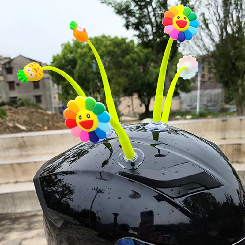 Yellow silicone sunflower decoration with suction cup attached to bicycle helmet, showing swinging motion