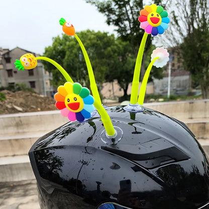 Yellow silicone sunflower decoration with suction cup attached to bicycle helmet, showing swinging motion