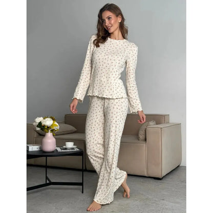 White floral print women's loungewear set with bell sleeve top and wide-leg trousers laid flat.