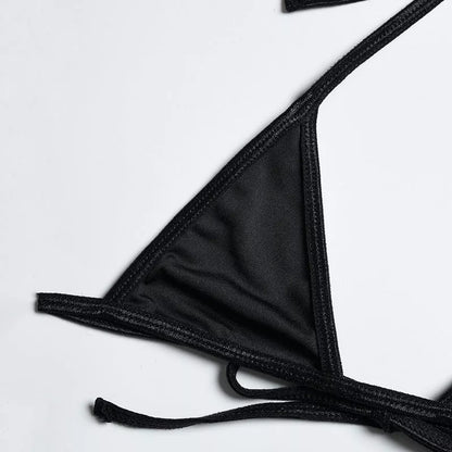 Solid black sling bikini set for women, includes bra, jacket, skirt, and shorts