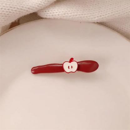 Red plastic hair clip with a 3D love heart and dots on a willow leaf-shaped base.