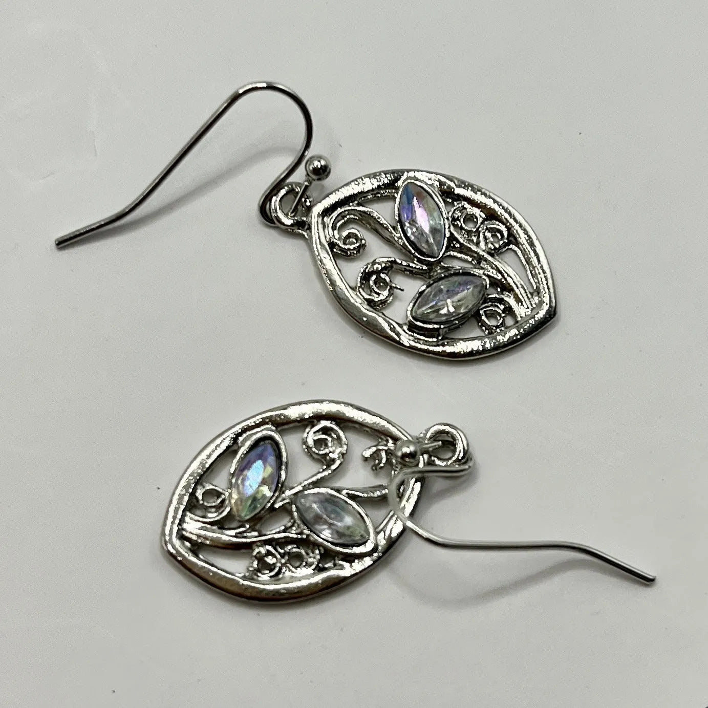 Silver leaf-shaped earrings with a central colourful moonstone on a white background.