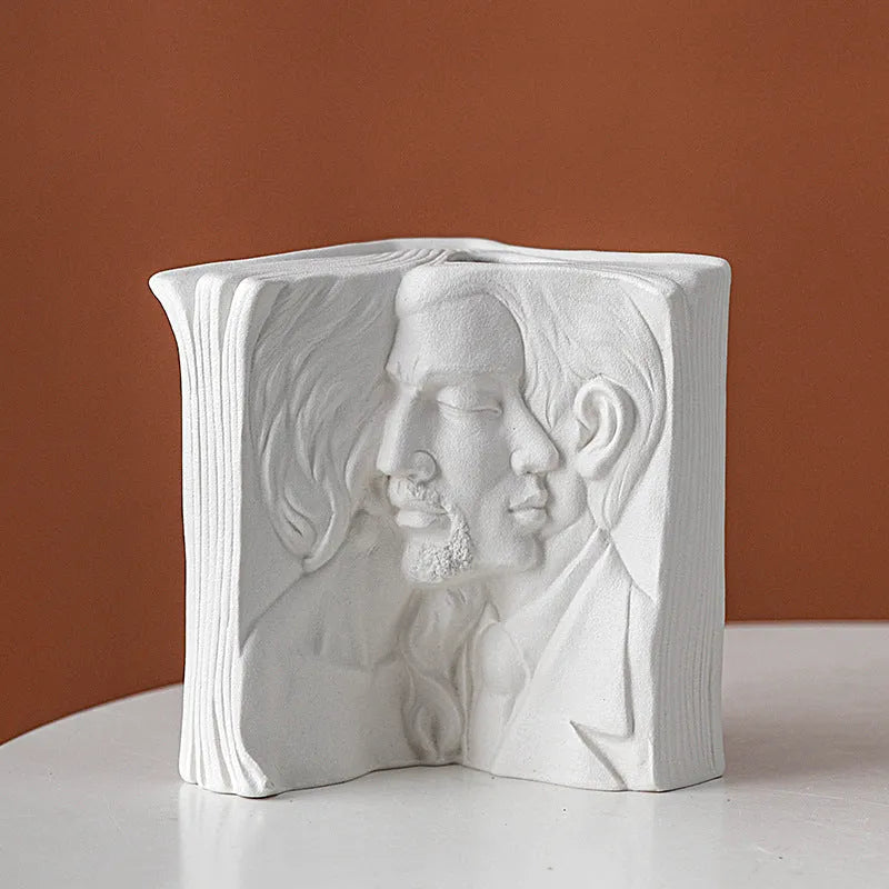 White ceramic book stand holding an open book at an angle, with a wire page holder in use.