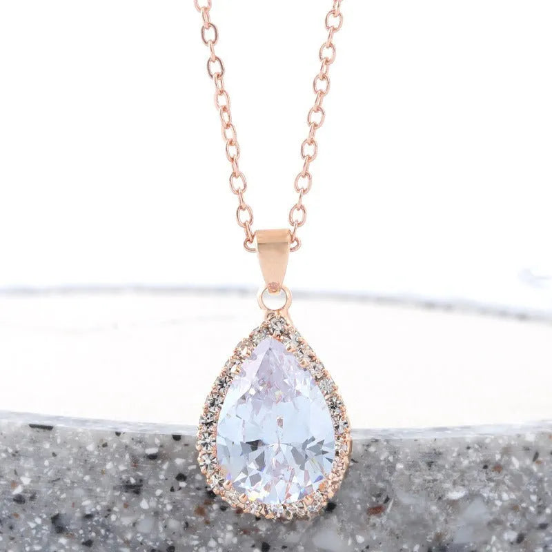 Rose gold geometric water drop pendant necklace on a model, showing adjustable chain and sparkling stone inlay.
