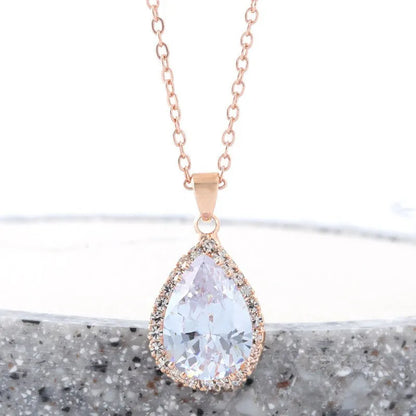 Rose gold geometric water drop pendant necklace on a model, showing adjustable chain and sparkling stone inlay.