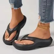Women's black thick-soled EVA flip-flops with a non-slip pattern on the sole.