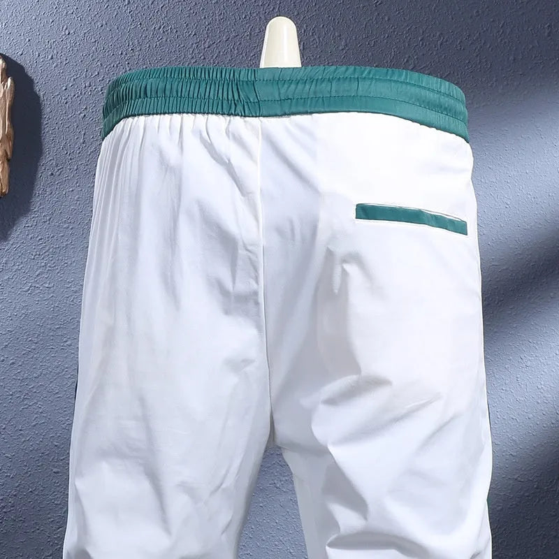 Men's ice silk skinny sports pants in black or white with striped tapered leg and ankle-tied hem